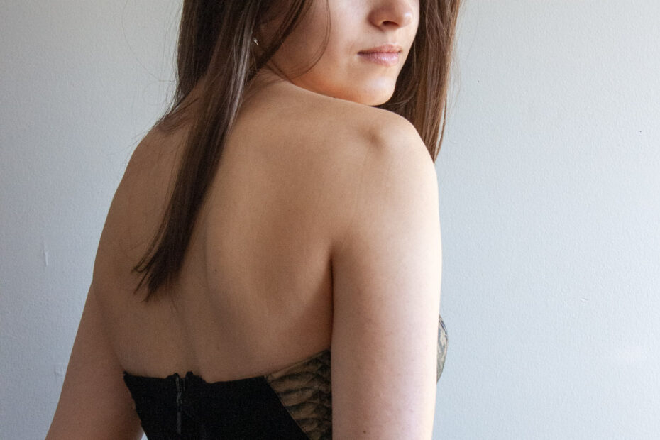 Beautiful woman with her back turned, looking over her shoulder to the camera.